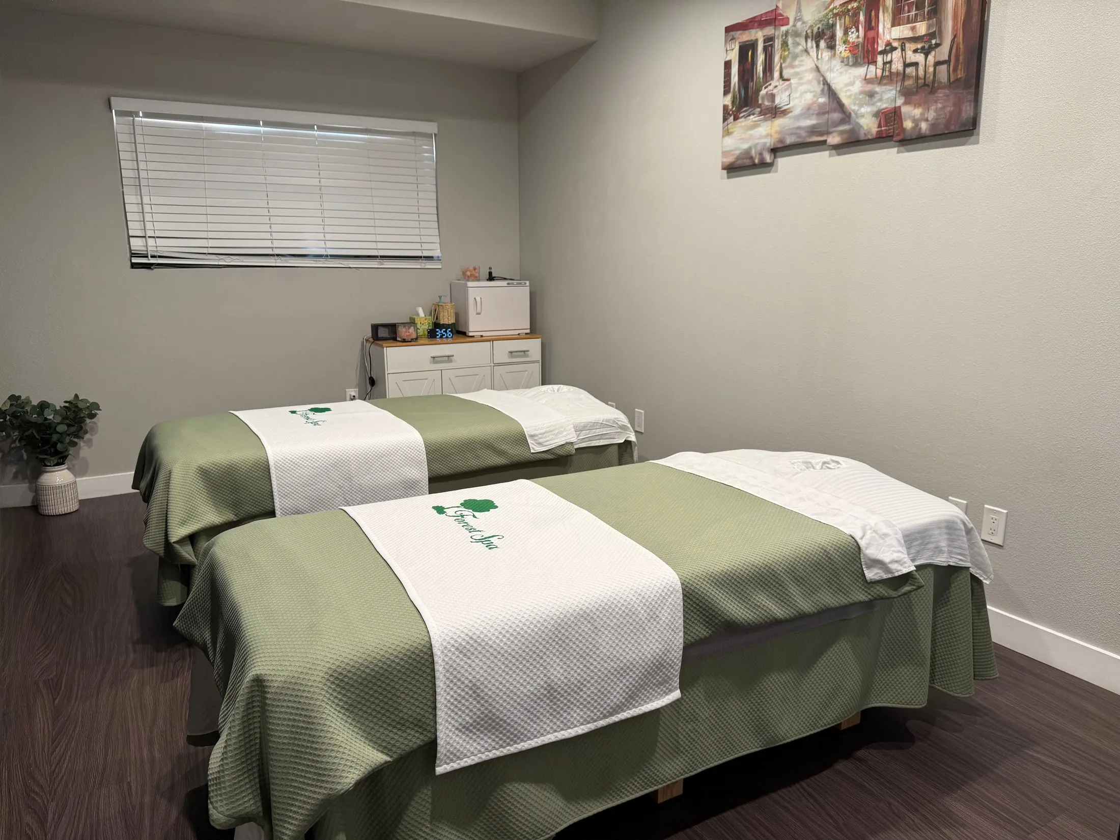 Couples massage room at Forest Spa in Poway with two massage tables in sage-green linens